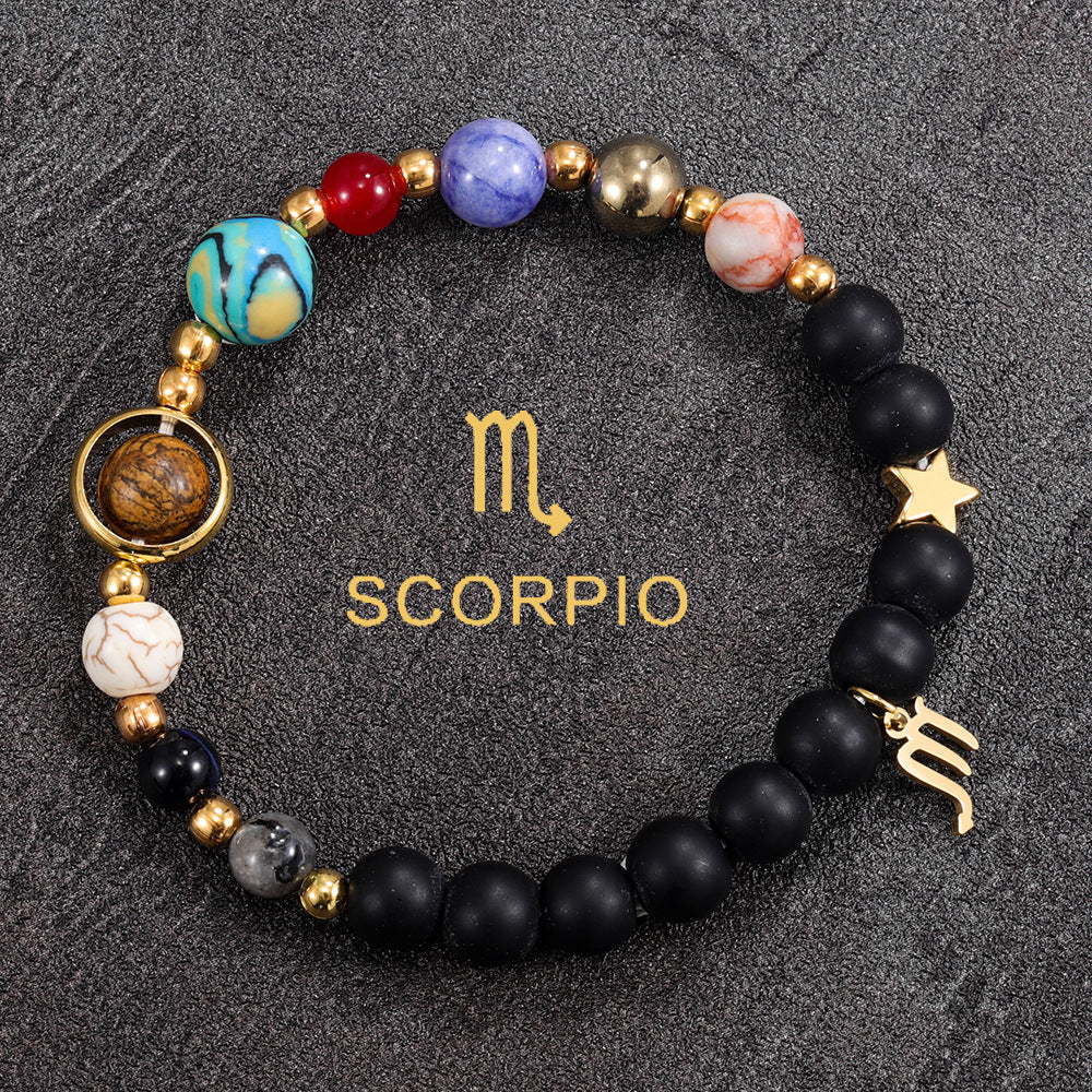Scorpio zodiac gemstone bracelet with deep blue, coral red, black onyx, and gold-tone charm by Velastrand